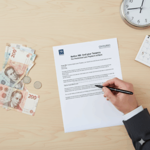 Overhead view of a paralegal's hand signing an Ontario N8 Notice: End Your Tenancy for Persistent Late Payment or Rent form, with cash and a calendar showing a due date on a wooden desk.